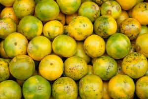 Orange fruits soiled organic stacked on wood crate in grocery photo