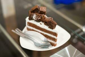 Chocolate cake and white cream on table photo