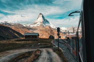 Matterhorn mountain with train running through on sunny day at Riffelboden, Zermatt, Switzerland photo