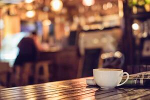 caliente Café exprés café taza con periódico en de madera mesa Encendiendo bokeh difuminar antecedentes foto