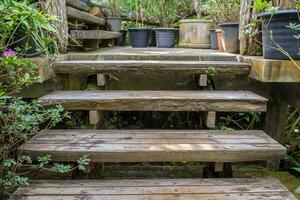 antiguo decaer madera escalera arriba en jardín foto