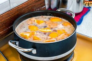 Cooking of oranges piece chewing with seasoning soup in pot photo