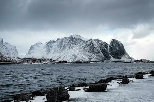 Nevado montaña con pescar pueblo en melancólico a lofoten islas foto