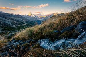 Matterhorn mountain with stream flowing on autumn wilderness in the morning photo