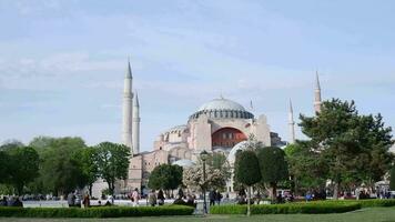 Istanbul, Turkey, May 02, 2023. A couple sits and chats on a bench with Hagia Sophia and Sultan Ahmet Park in the background. A very popular tourist place video