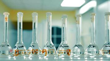 Volumetric Flasks in Science Lab. Row of volumetric flasks with clear liquid in a scientific laboratory. video