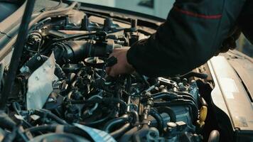 motor mecánico ajustando coche parte, enfocado técnico a trabajar. un experto motor mecánico ajusta un coche parte con un llave, exhibiendo precisión y atención en un profesional automotor taller. video