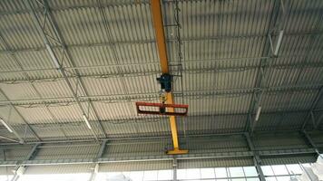 Industrial Overhead Crane in a Modern Warehouse. Large yellow overhead crane in industrial warehouse setting, no cargo attached video