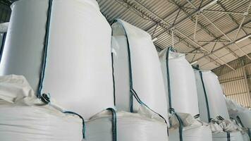 Large Sacks of Agricultural Product in Storage Warehouse. Stacked white sacks of grains or agricultural products in a storage facility video