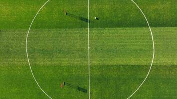 aéreo ver de un fútbol campo con formación equipo. zumbido ver de un fútbol campo con postes de la portería y un soltero pelota a el centrar video