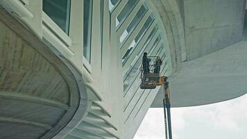 Maintenance Work on Modern Bridge Architecture. A worker performing essential maintenance on the underside of a contemporary bridge. video