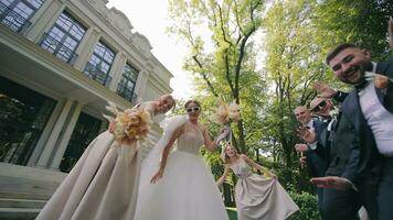 Braut und Bräutigam tanzen ein tanzen zusammen mit ihr Freundinnen. glücklich jung Menschen Tanzen. froh Hochzeit Party Laufen draußen Veranstaltungsort. video