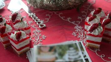 Appetizing, sweet, delicious cakes with strawberries on a red table. video