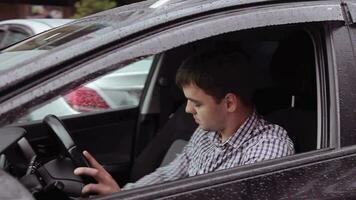 un joven hombre es montando en un negro coche video