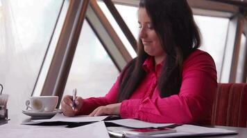 Young beautiful business woman with dark long hair working with office documents during office hours video