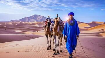 AI generated Camel rider with camels travelling over dunes in the desert photo