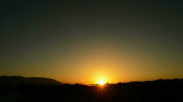 Sol se escondendo dentro a montanhas e avião aterrissagem video