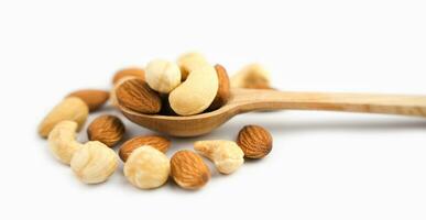 Mix of nuts almond, hazelnut and cashew in wooden spoon isolated on white background. Healthy snack. Banner. Close-up. photo