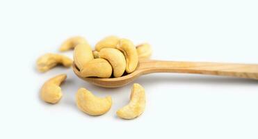 Tasty cashew nuts in wooden spoon isolated on white background. Close-up. Banner. Selective focus. photo