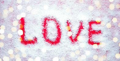 The word LOVE is written in the snow. Close-up. Top view. photo