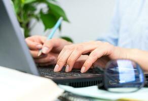 A young woman works at a computer. Close-up. Selective focus. photo