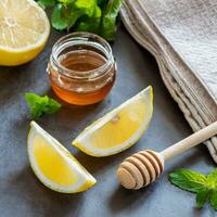 Honey in jar with honey dipper on vintage wooden background photo