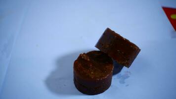 black cylindrical palm sugar isolated on white background, top view photo