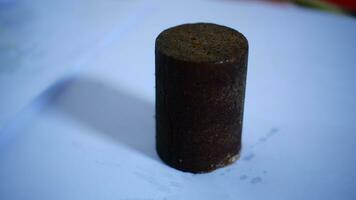 black cylindrical palm sugar isolated on white background, top view photo