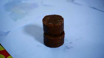 black cylindrical palm sugar isolated on white background, top view photo
