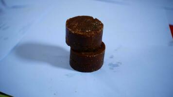 black cylindrical palm sugar isolated on white background, top view photo