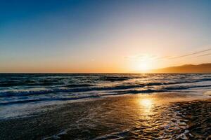 Sunset on the beach reflecting in the ocean photo