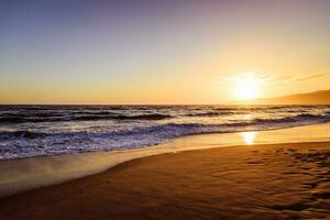 Sunset on the beach reflecting in the ocean photo