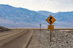 Empty American highway in the Death Valley with a 13 miles of curvy road sign photo