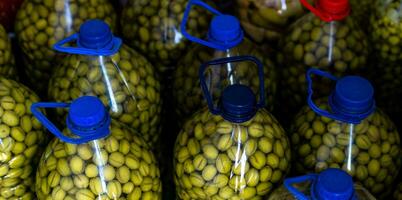 hogar envase, verde aceitunas en escabeche en el plastico botellas foto