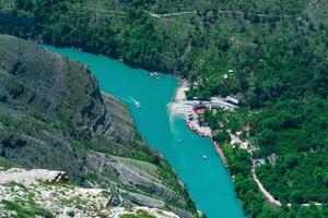 top view of the mountain river Sulak in Dagestan with a tourist boat jetty photo