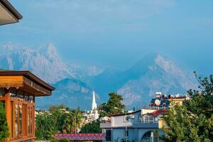 landscape with distant blue mountains behind city rooftops, Kemer, Antalya, Turkey photo