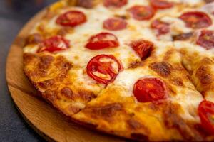 pizza margherita on a wooden plate close-up photo