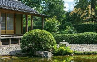 tea house behind pond in japanese garden photo