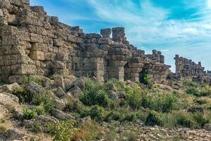 ruins of ancient city walls against the backdrop of the sky with moon in Side, Turkey photo