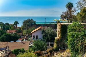 view of Kaleici, coastal historical city center of Antalya, Turkey, with open-air restaurant at the top of the ancient fortress wall photo