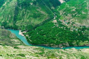 aerial view of the village of Old Zubutli in the valley of the Sulak River in Dagestan, small mountain settlement in a deep canyon with a jetty for motorboats photo