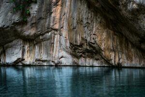 clean blue river with rocky banks at the bottom of a deep canyon photo