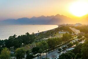 puesta de sol paisaje de Konyaalti playa desde cerca rocas en antalya, pavo. beydaglari montañas en niebla son visible en el antecedentes. foto