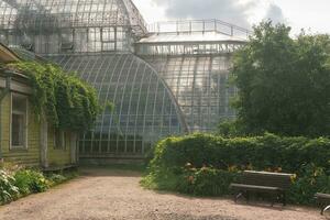 esquina de un antiguo botánico jardín con un enorme Clásico invernadero en el antecedentes foto