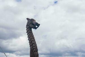 figurehead on the bow of a full-scale replica of a viking ship, against a sky photo