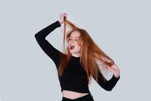 young woman with tousled hair stretches on a light background photo