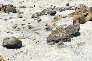 volcanic bombs among the tephra in a fumarole field on the slope of a volcano photo