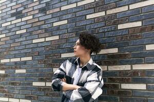 young man posing against a brick wall photo