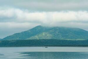 sea bay with foggy mountains in the background, view of the Mendeleev volcano on a cloudy day photo