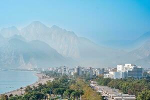 ver de Konyaalti playa desde cerca rocas en antalya, pavo. beydaglari montañas en niebla son visible en el antecedentes foto